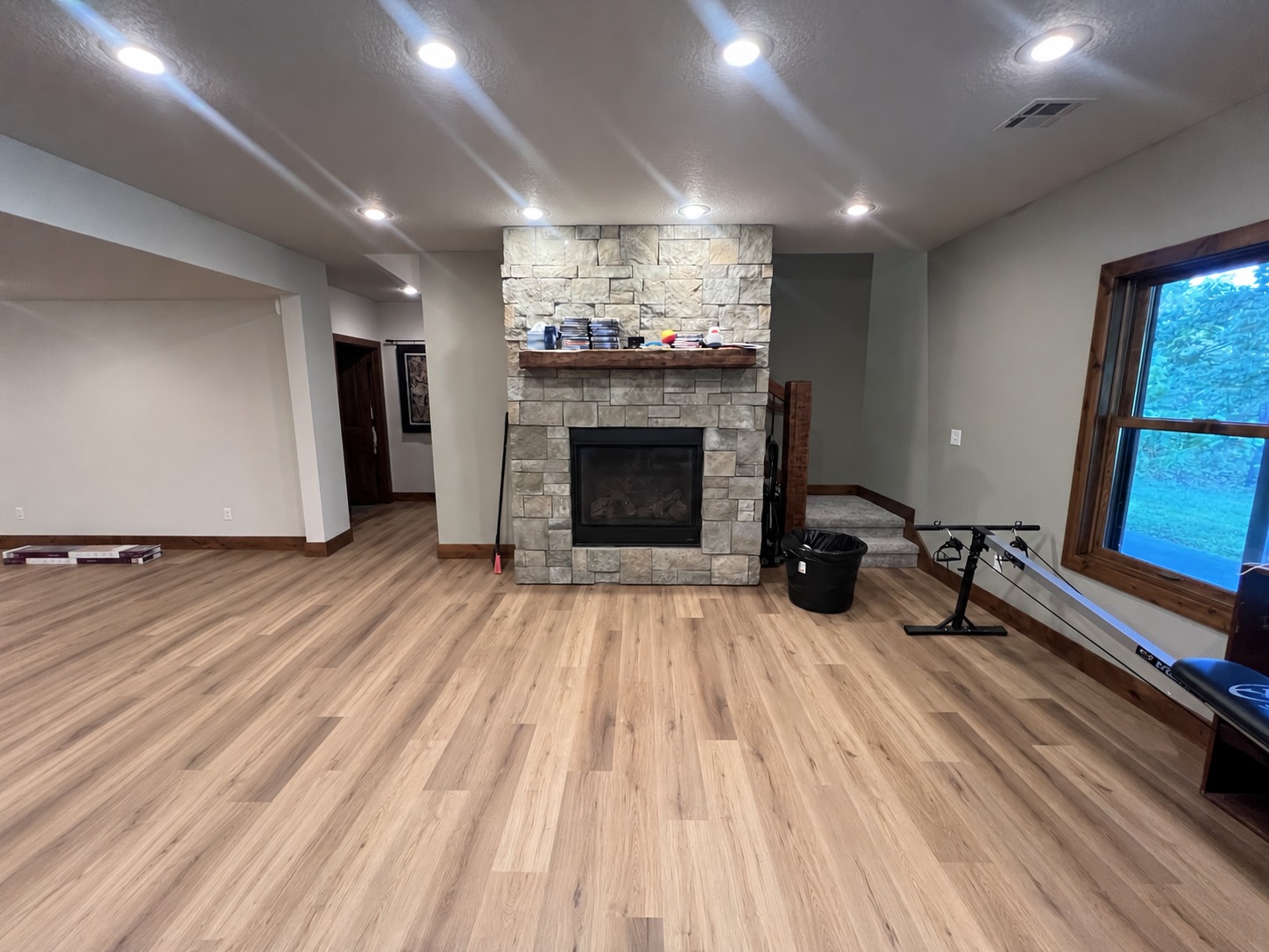 Wood-look plank flooring surrounding a stone fireplace